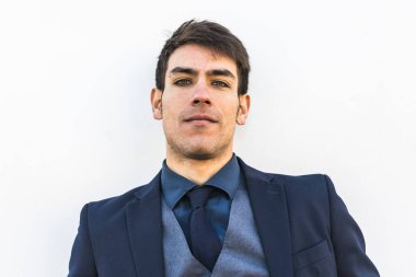 Beyaz takım elbiseli, dışarıda yaşayan çekici bir adamın portresi. Belden yukarı vuruş..