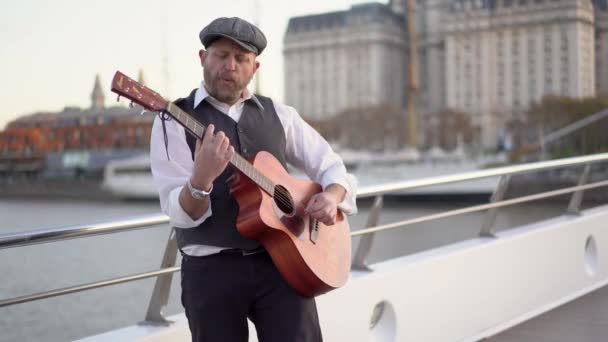 Een Straatmuzikant Die Gitaar Speelt Terwijl Hij Buiten Fluit — Stockvideo