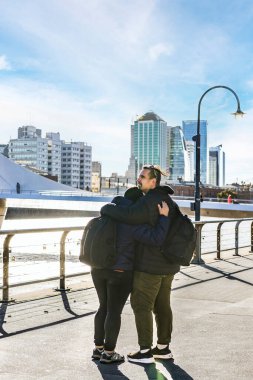 LGBT çifti Buenos Aires, Arjantin 'de Puerto Madero' yu ziyaret ederken birbirlerine sarılıyorlar. Gezginler. Boşluğu kopyala
