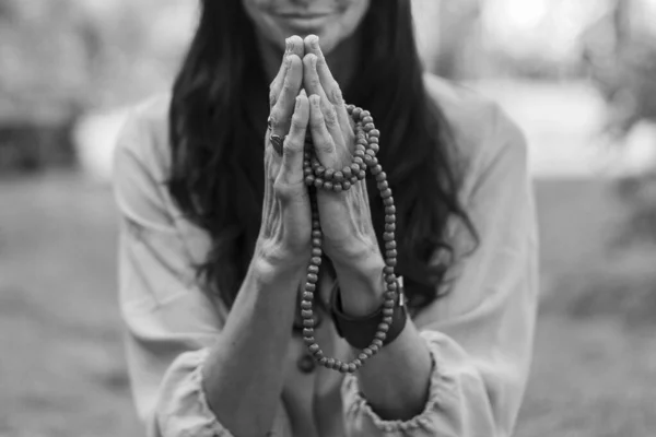 Yogada meditasyon yapan bir kadın. Kali Mudra dışarıda japa mala tutuyor.. 