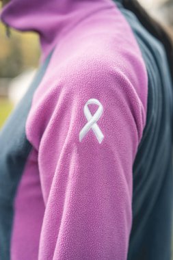 Üzerinde nakışlı kanser farkındalığı kurdelesi olan sweatshirt giyen bir kadının yan görüntüsü. Dikey Çekim