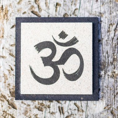 Top angle view of an Om sign on tree trunk. Yoga and meditation concept. clipart