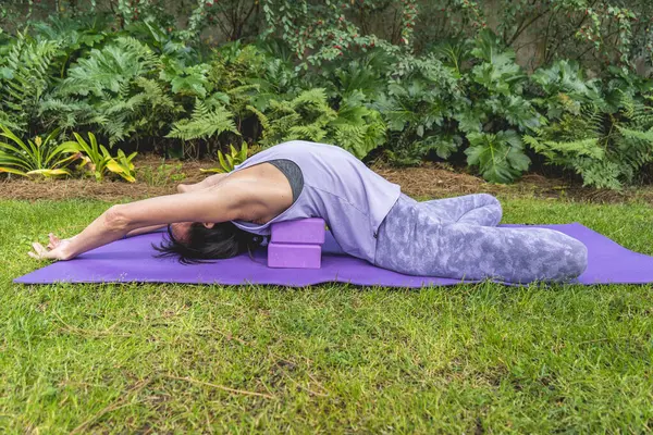 Woman relaxing on yoga blocks. Copy space