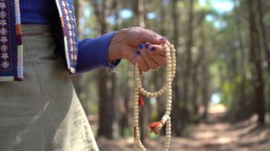 Japapa Mala 'yı tutarken dua eden bir kadının yakın çekimi.