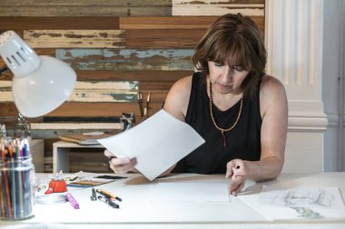 Yeni tasarımlar üzerinde çalışan bir moda tasarımcısının ön görüntüsü