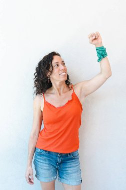 Arjantin 'de kürtajın yasallaştırılmasının bir sembolü olarak bileğinde bir eşarpla kolunu havaya kaldıran bir kadın görülüyor. Dikey çekim.