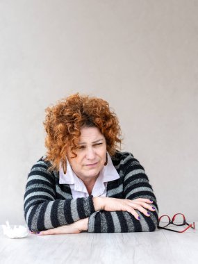 Orta yaşlı kızıl saçlı bir kadın kendini hasta hissediyor.