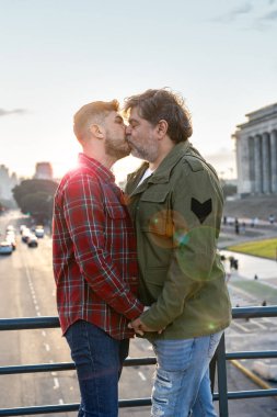 Buenos Aires 'te gün batımında öpüşen İspanyol eşcinsel çift. Dikey çekim