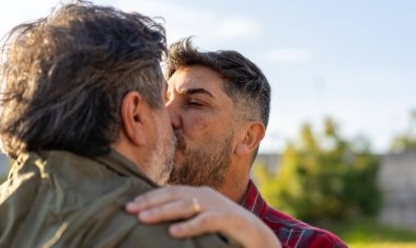 Açık havada öpüşen evli bir eşcinsel çiftin yakın çekimi.