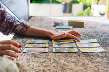 Kartları okuyan bir tarot okuyucusunun el görüntüsü