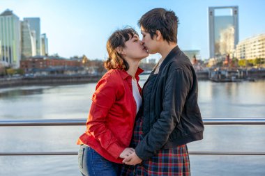 Young LGBT couple of women holding hands and sharing a kiss clipart