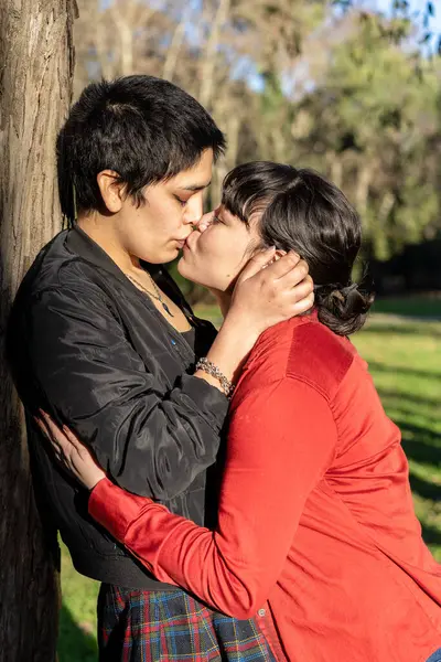 LGBT 'li iki kadın ağaca karşı tutkulu bir öpücük paylaşıyor.