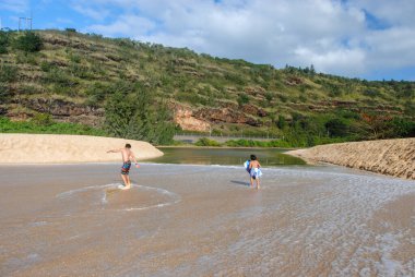 Oahu, Hawaii, ABD - 19 Şubat 2022: Waimea Nehri 'nin Waimea Körfezi' nde okyanusla buluştuğu tahtalarla oynayan çocuklar