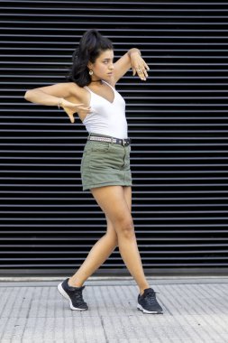 Kentli bir şekilde dans eden genç bir kadının dikey çekimi..