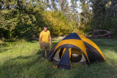 Maceracı sakin ormanda çadır kuruyor.
