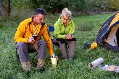 Ormanda sıcak içecekler yudumlayan çiftle huzurlu bir an.