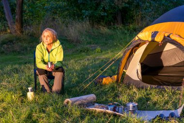 Sıcak kahvenin tadını çıkaran bir kadın.