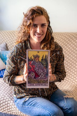 Bir Tarot okuyucusu dev bir Tarot kartı gösteriyor. İmparatoriçe.
