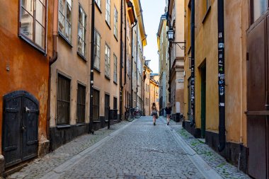 Gamla Caddesi 'nde büyüleyici dar bir sokakta yürüyen iki genç kadın.
