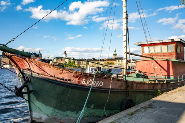 Arkasında Stockholm manzarası olan eski bir tekne.
