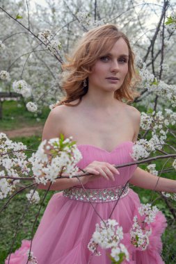 Çiçek açan bahçede bir kızın portresi. Çiçek açan ağaçlar, geleneksel Asyalı, seyahat, mevsimlik nisan arkaplanı.