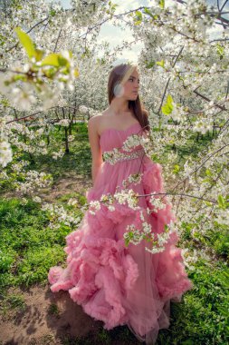 Çiçek açan bir bahçede güzel bir gece elbisesi giymiş Asyalı bir kızın portresi. Çiçek açan ağaçlar, Japon Hanami Sakura Festivali seyahat, mevsimlik.