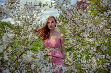Çiçek açan bir bahçede güzel bir gece elbisesi giymiş Asyalı bir kızın portresi. Çiçek açan ağaçlar, Japon Hanami Sakura Festivali seyahat, mevsimlik.