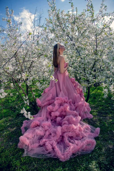 Çiçek açan bir bahçede güzel bir gece elbisesi giymiş Asyalı bir kızın portresi. Çiçek açan ağaçlar, Japon Hanami Sakura Festivali seyahat, mevsimlik.