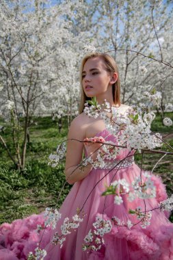 Çiçek açan bir bahçede güzel bir gece elbisesi giymiş Asyalı bir kızın portresi. Çiçek açan ağaçlar, Japon Hanami Sakura Festivali seyahat, mevsimlik.