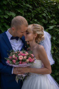Parkta öpüşen düğün çifti. Yaz düğünü.