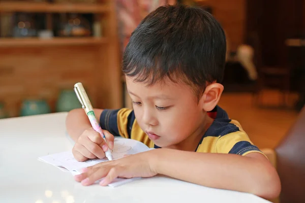 Asyalı Küçük Çocuk Sınıfta Masasında Kalemle Kitap Çiziyor — Stok fotoğraf