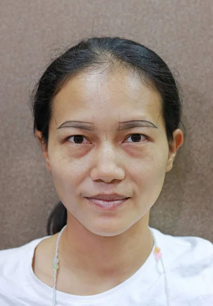 Portrait of Asian woman with shaving eyebrow before tattoo eyebrows.