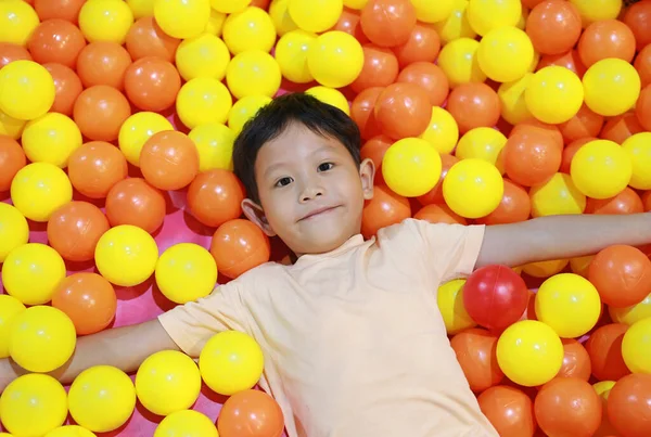 亚洲小男孩在五彩缤纷的塑料球场上玩耍 — 图库照片
