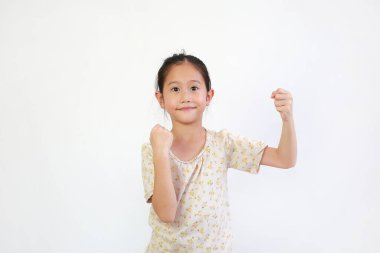 Asyalı kız çocuğu beyaz arka planda teması olmayan bir şeyi tutarken yüz ifadesi gösteriyor..