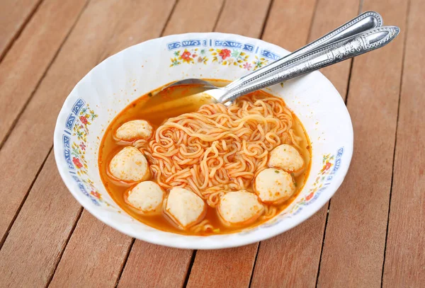 stock image Instant noodles in ceramic bowl against wooden plank.