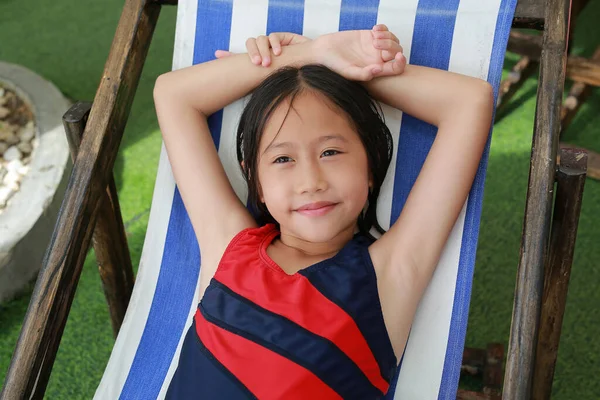 身着泳衣 头发湿透的亚洲女孩躺在游泳池边帆布床上的画像 — 图库照片