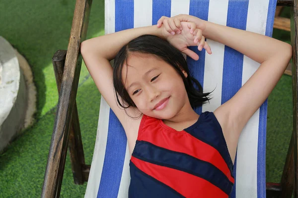 身着泳衣 头发湿透的亚洲女孩躺在游泳池边帆布床上的画像 — 图库照片