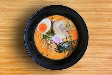 Chashu Pork, yosun ve kaynamış yumurtanın bambu ahşap arka planda olduğu Tsukemen Ramen Asya eriştesi..
