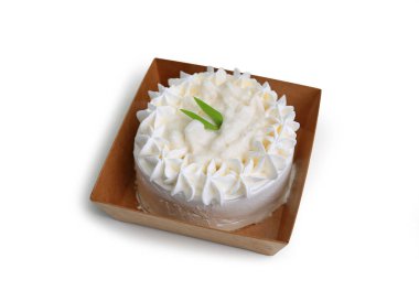 Beyaz arka planda izole edilmiş kağıt tepside hindistan cevizi kremalı kek..