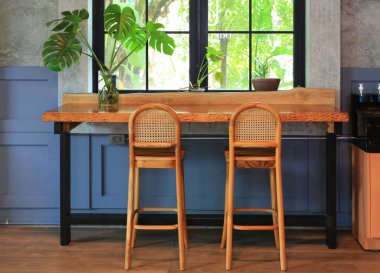 Kafede boş ahşap masa ve sandalyeler. Cam pencereye karşı koltuk ve ahşap tezgah. Kafe tasarımı.