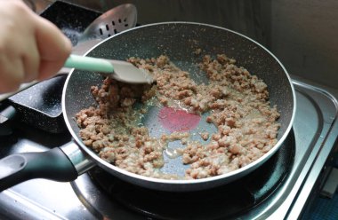 İnsanlar tavada kızartılmış domuz eti veriyor..