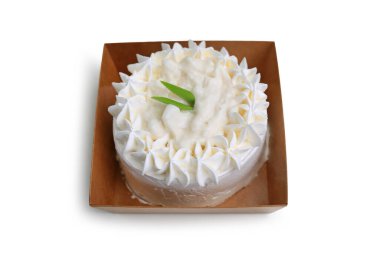 Beyaz arka planda izole edilmiş kağıt tepside hindistan cevizi kremalı kek..