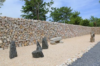 Arka planda çelik parmaklık olan taş duvara karşı süsleme taşı. Perspektif görünümü.