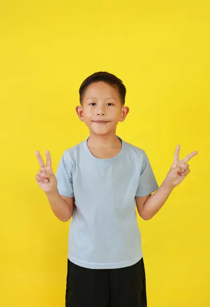 Ázsiai Kisfiú Gyerek Mutatja Győzelem Jel Ujjak Egyenesen Néz Miközben Stock Kép