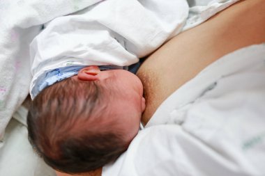 Yakın plan bebek anne memesinden besleniyor..