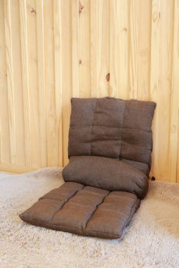 Tahta duvara yaslanmış yumuşak koltuk minderleri. Oturma odasındaki portatif koltuk ya da katlanabilir kanepe..