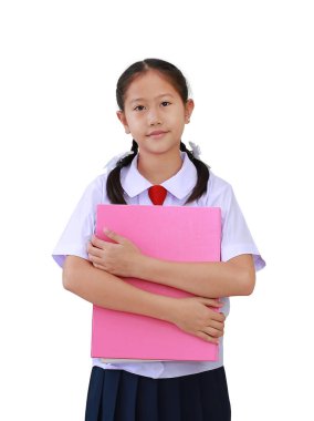 İlkokul üniformalı Asyalı kız elinde kitapla dikilip beyaz arka planda izole edilmiş kameraya bakıyor. Okul konseptine dönelim..