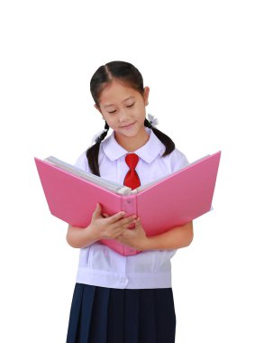 İlkokul üniformalı Asyalı bir kız öğrencinin portresi beyaz arka planda izole bir şekilde açık bir kitap tutuyor. Clipping yolu ile resim.