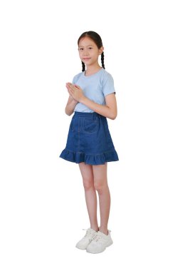 Smiling Asian girl kid in neat outfit pay respect or pray posture isolated on white studio background. Full body photo side view with clipping path. clipart