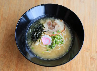 Miso Ramen Asya eriştesi, chashu domuz eti, deniz yosunu ve bambu ahşap arka planda kaynamış yumurta..